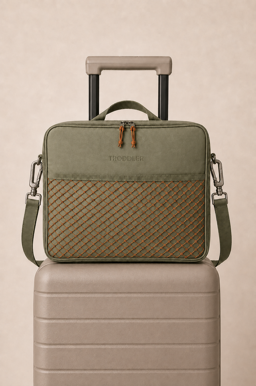 TRODDLER bag resting on a suitcase — front with wordmark and storage net